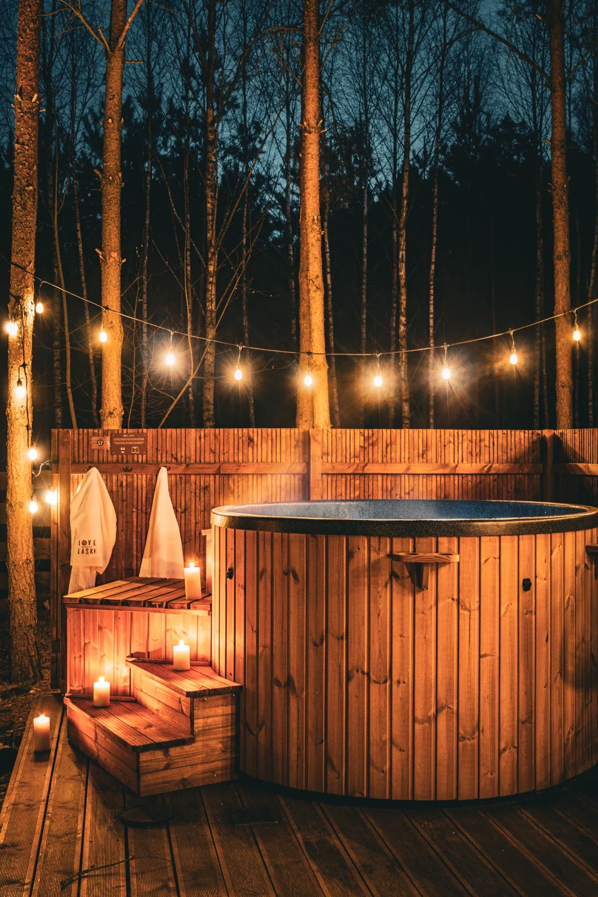 The hot tub beneath evening string lights