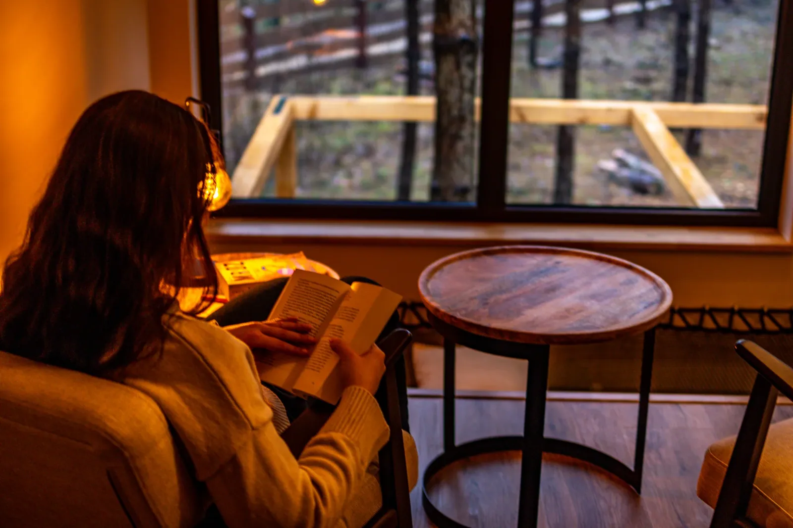 An evening read by the forest-facing window