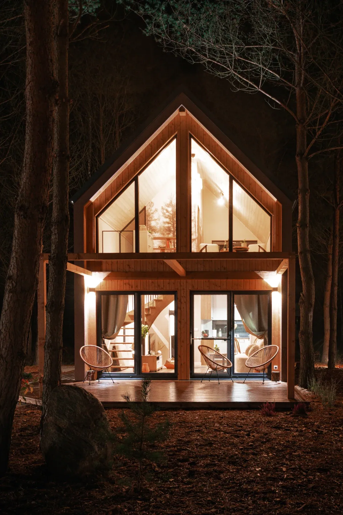 A cabin lit up against the night-time forest