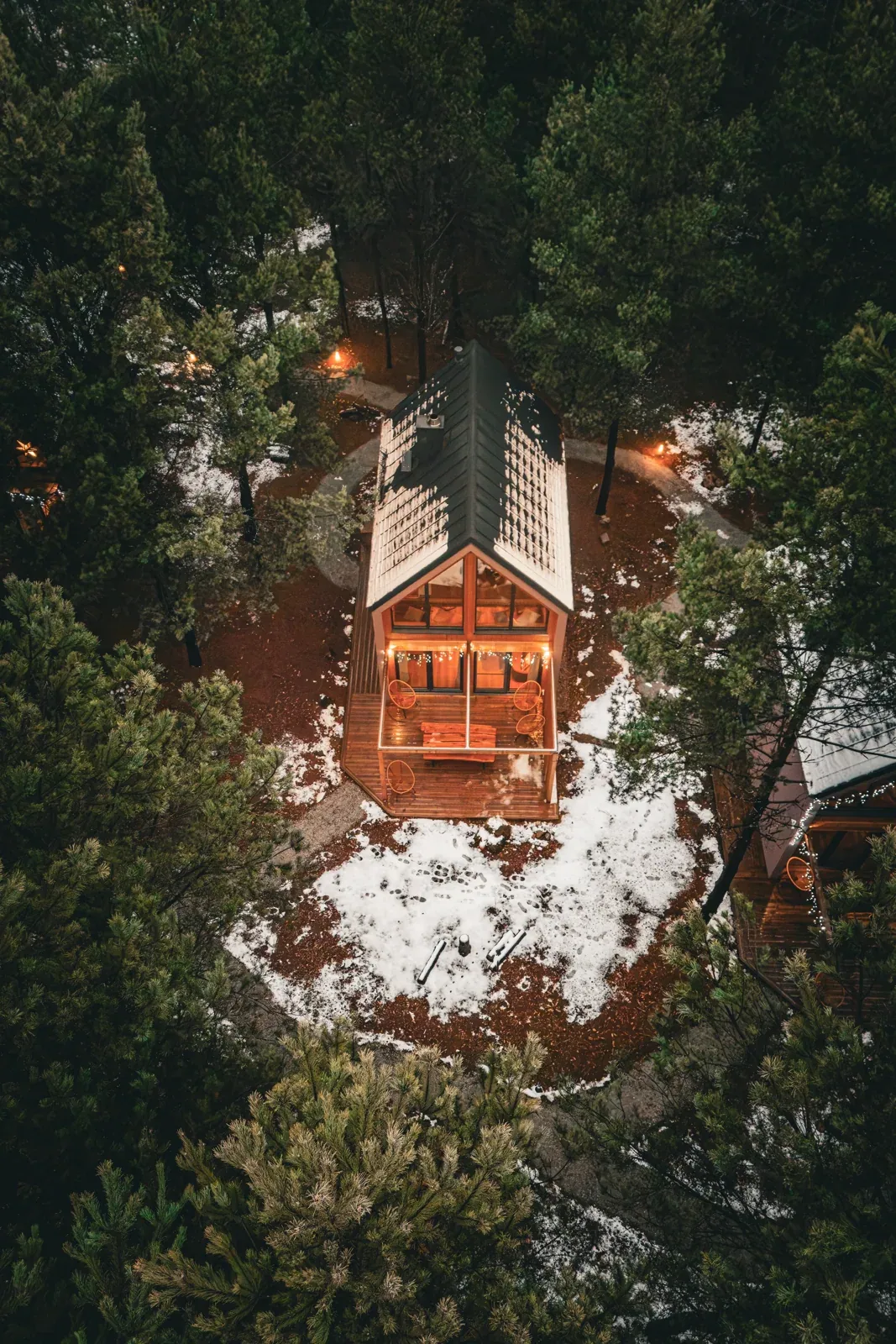 A bird's-eye view of a cabin in the winter forest
