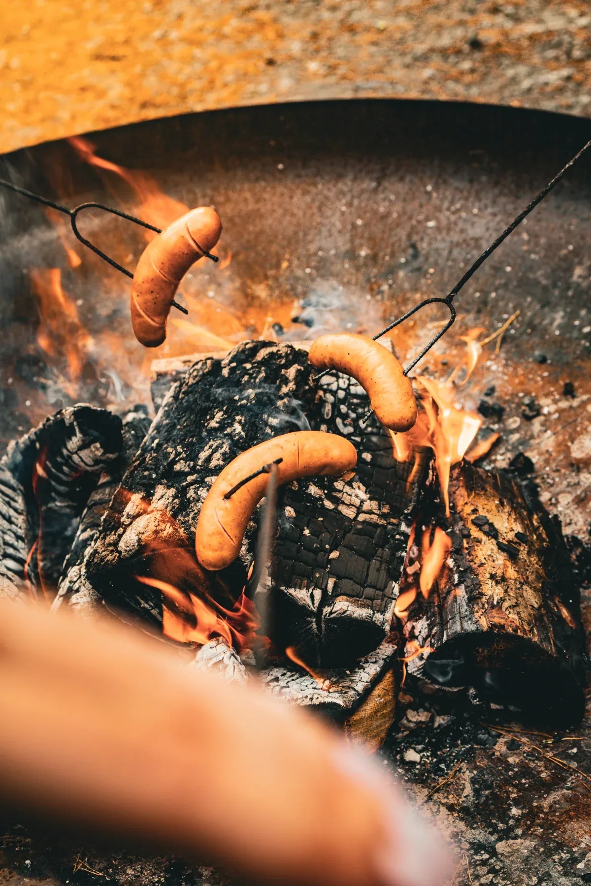Roasting sausages over the campfire